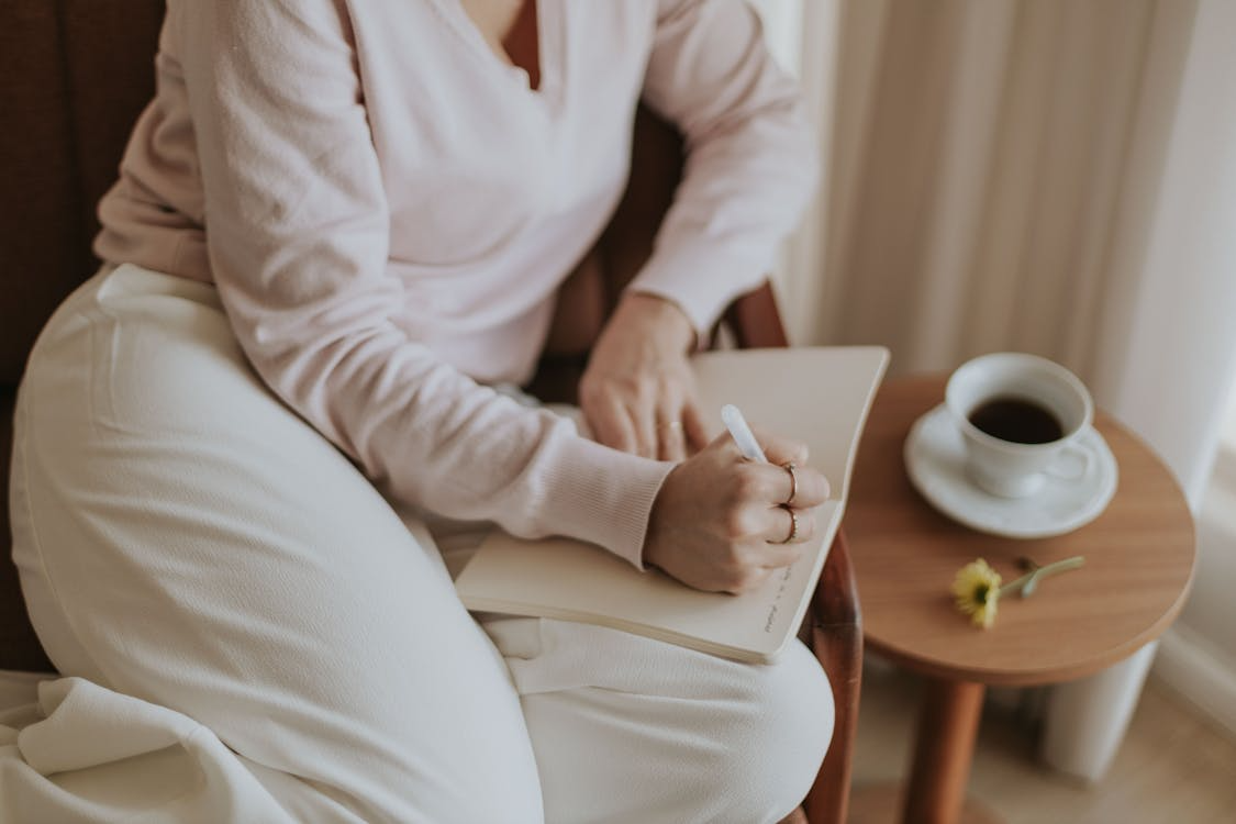 Woman journaling with coffee as one of the small daily habits that make life more interesting.