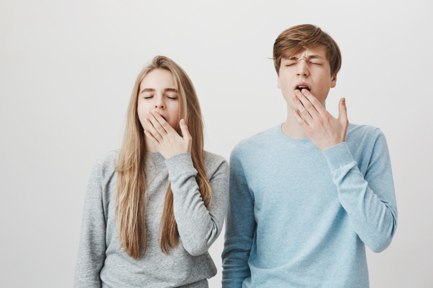 Two people yawning together as one of the everyday mysteries explained through science.