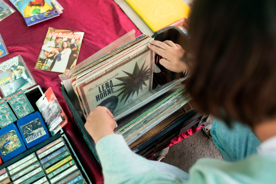 Person browsing vinyl records to show why people collect things through nostalgia.