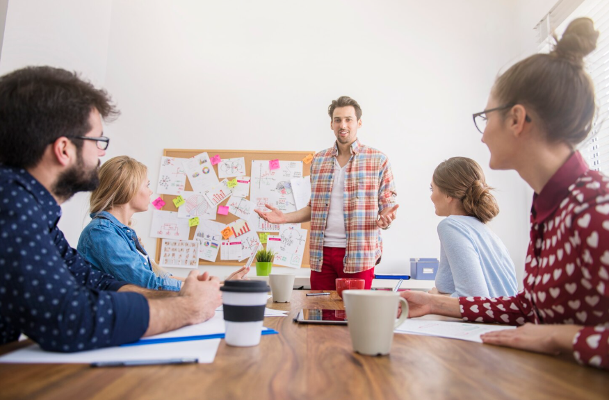 Person presenting ideas to a group showing transferable skills that pay off through communication and teamwork.
